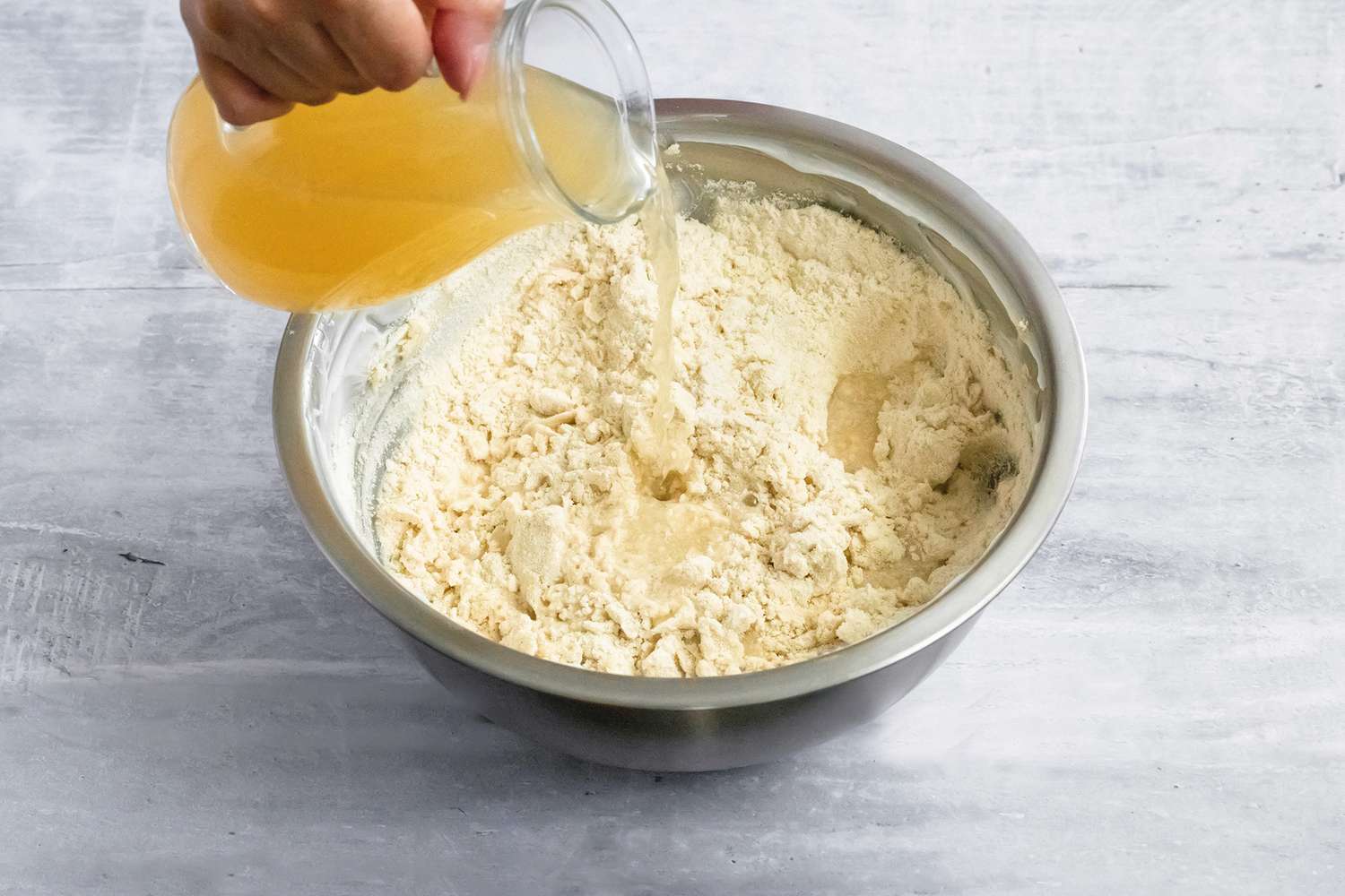 Broth Poured into Bowl of Tamales Dough