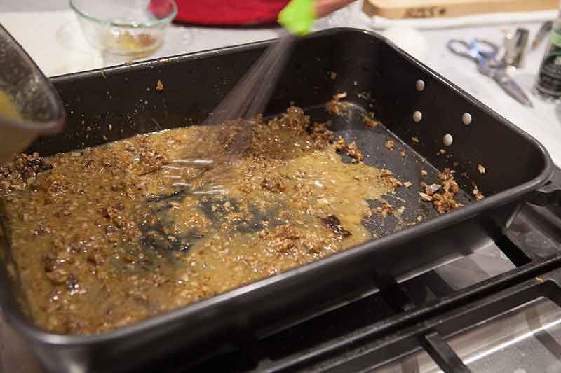 A giblet mixture being whisked in a baking dish