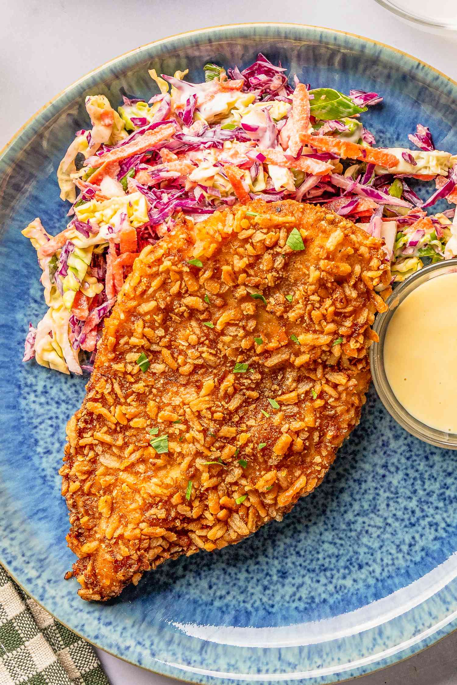 pretzel chicken with a side of cole-slaw and a bowl of honey dijon, all on a plate