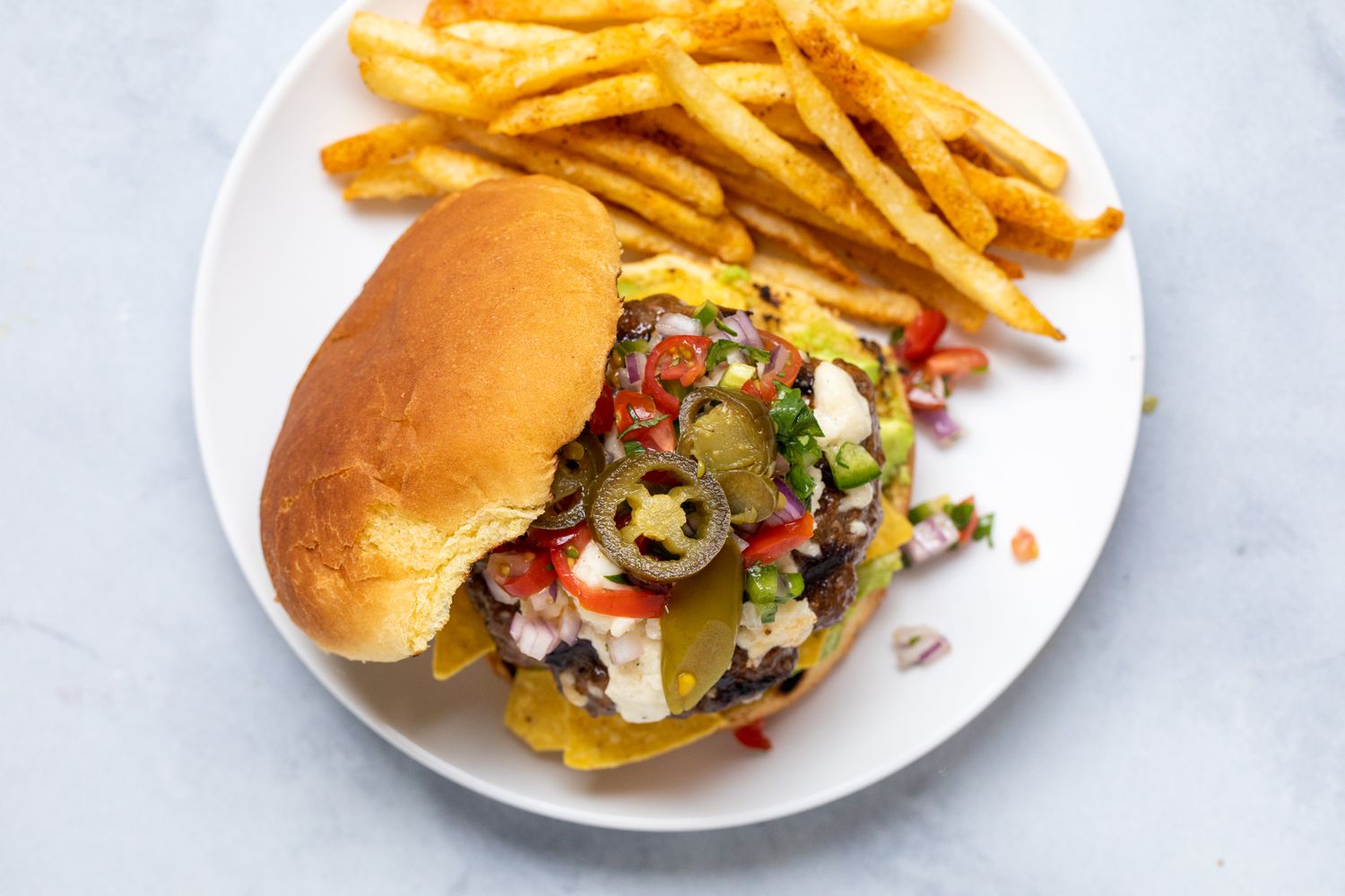 Overhead view of an avocado burger with a side of fries.