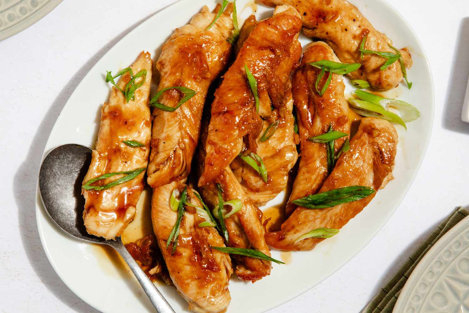 hot honey tenders on a platter with a serving spoon