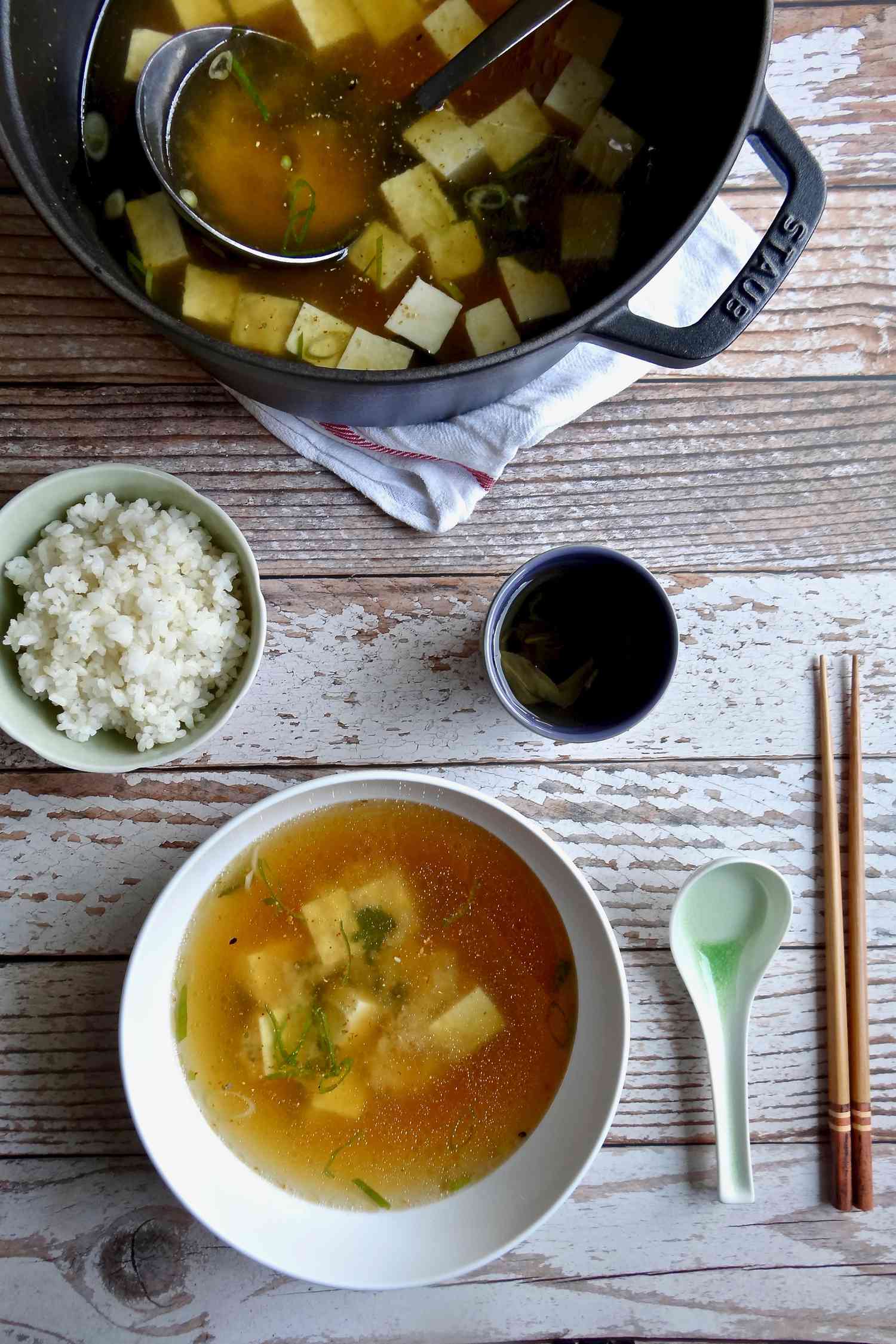 Quick and easy miso soup in a bowl set on a table along with a pot of soup.