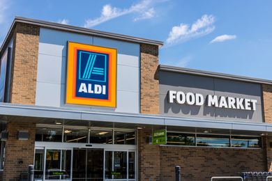 Ground level view of an Aldi storefront with the Aldi logo visible above the doors