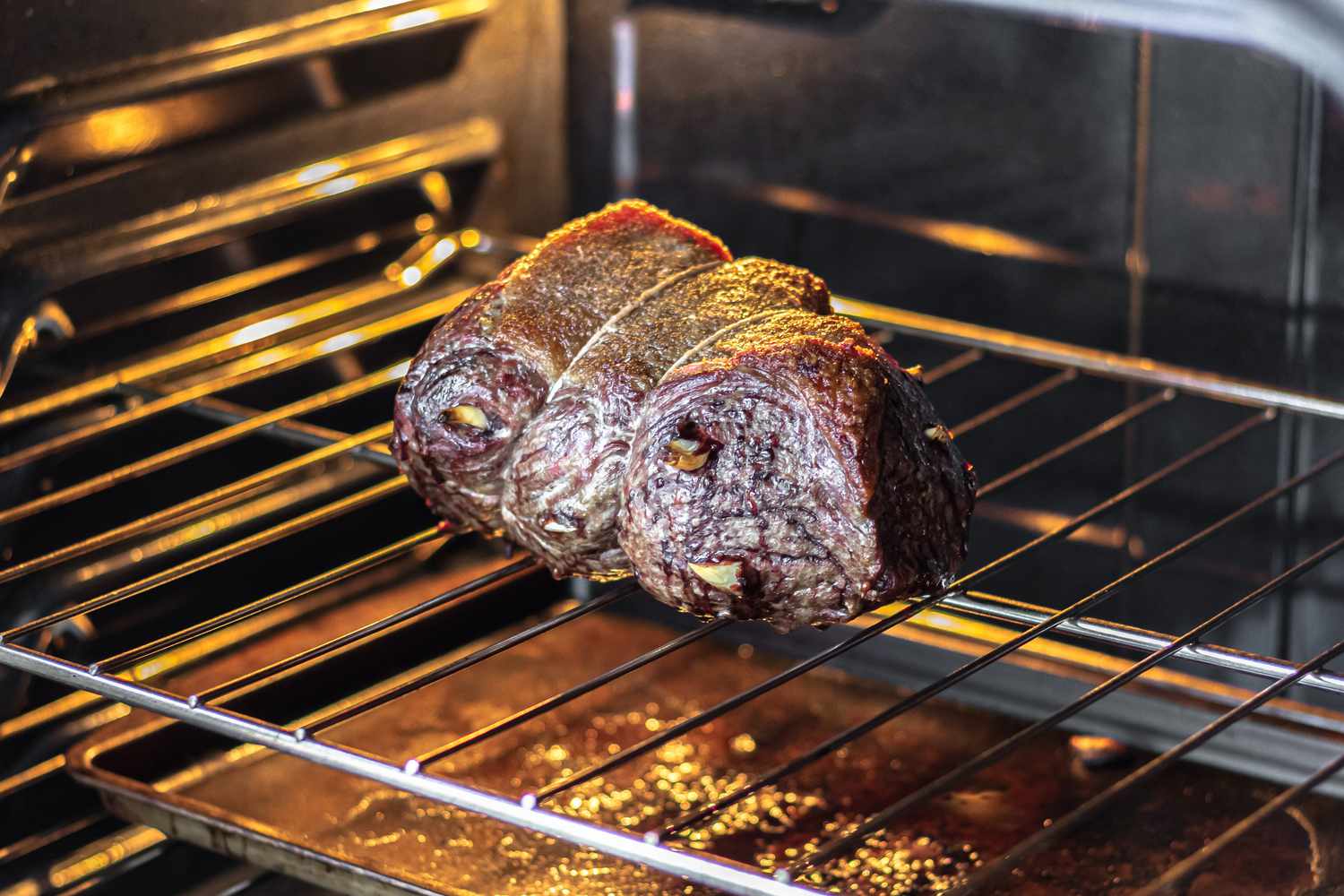 A beef roast cooking in an oven