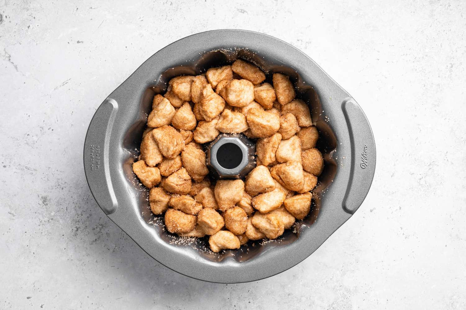 Monkey Bread Pieces Placed in a Buttered Bundt Pan 