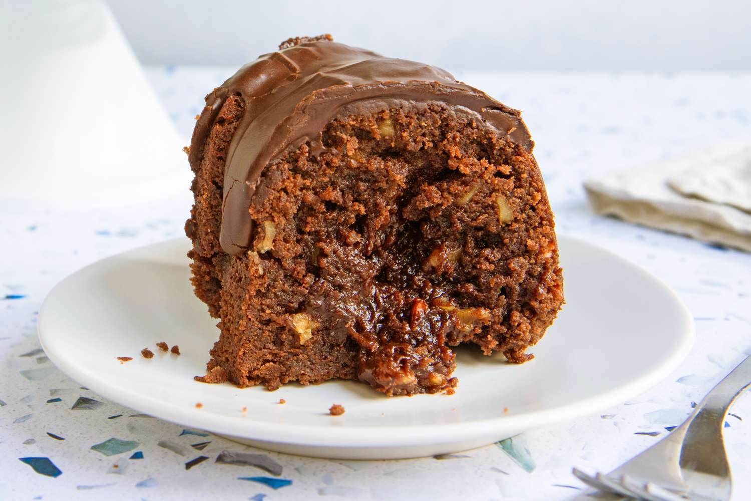 A slice of chocolate cake with a gooey filling served on a white plate