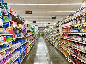 A grocery store aisle with shelves stocked on both sides
