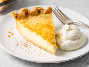 Slice of Egg Custard Pie on Plate with Cream