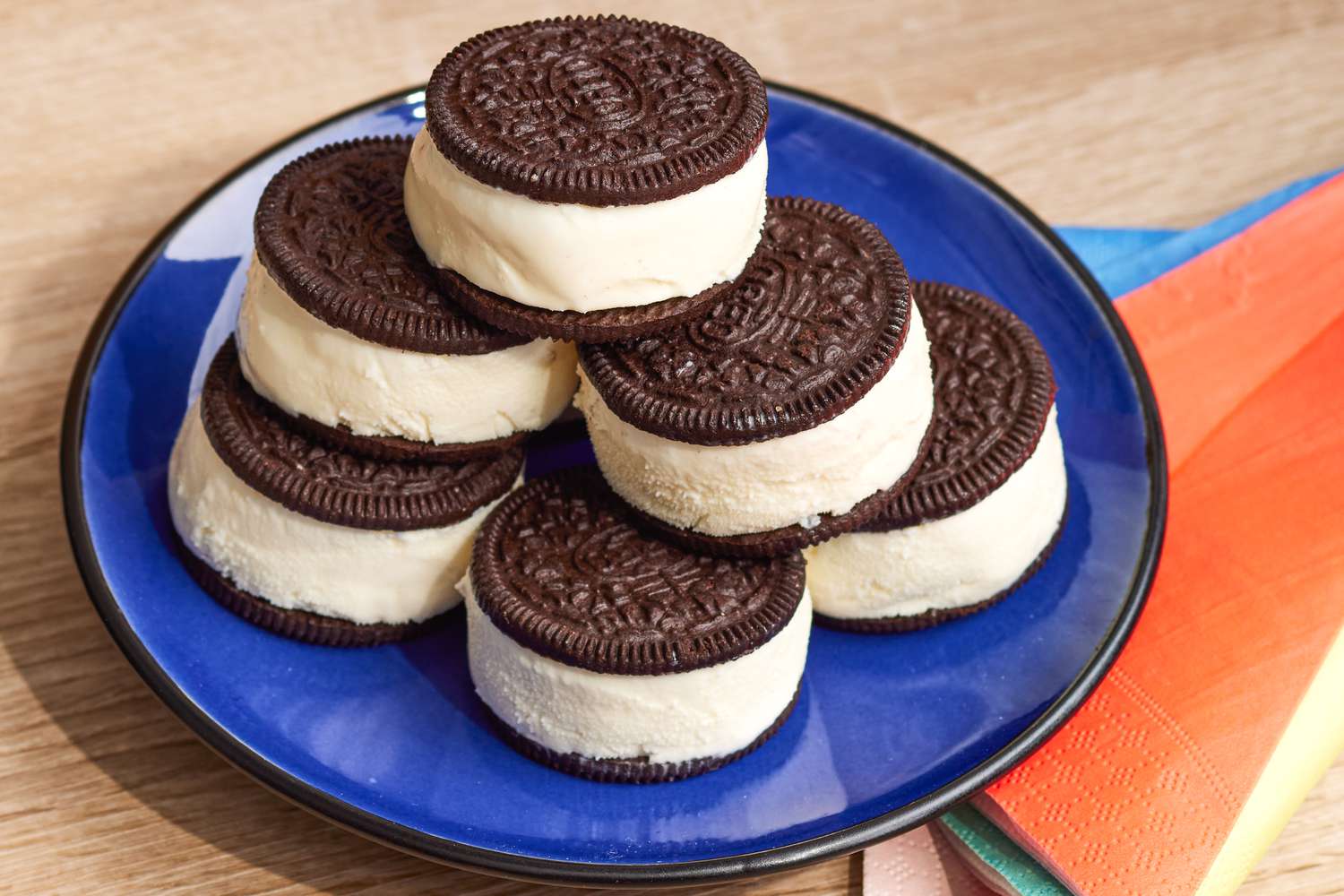 2-Ingredient Oreo Ice Cream Sandwiches Stacked on a Plate Next to Colorful Single Use Napkins
