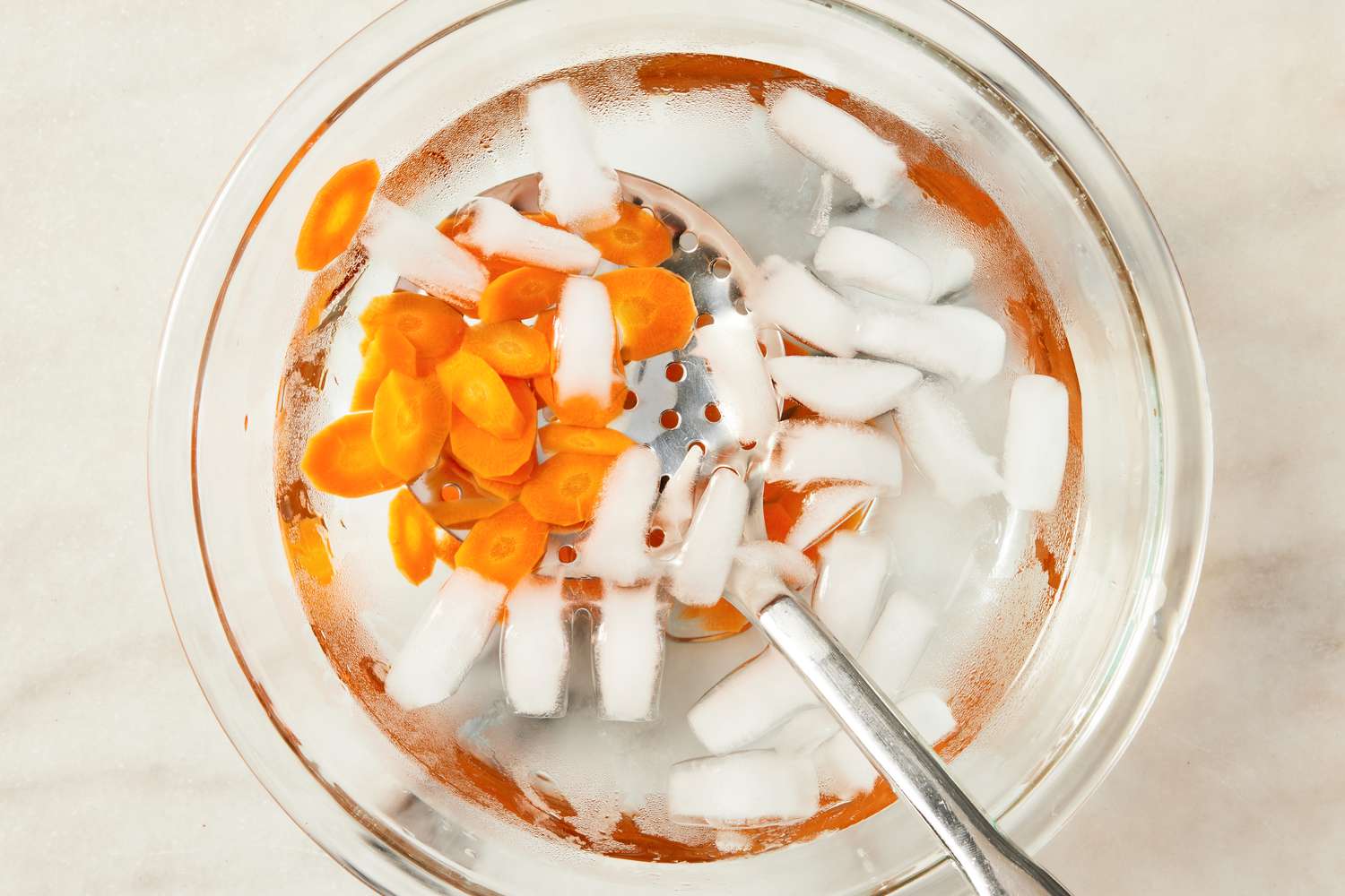 blanched carrots in a bowl of ice water for Korean-style potato salad recipe