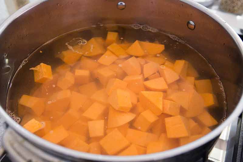 Cubes of yams (garnet sweet potatoes) in a saucepan ready to boil in water