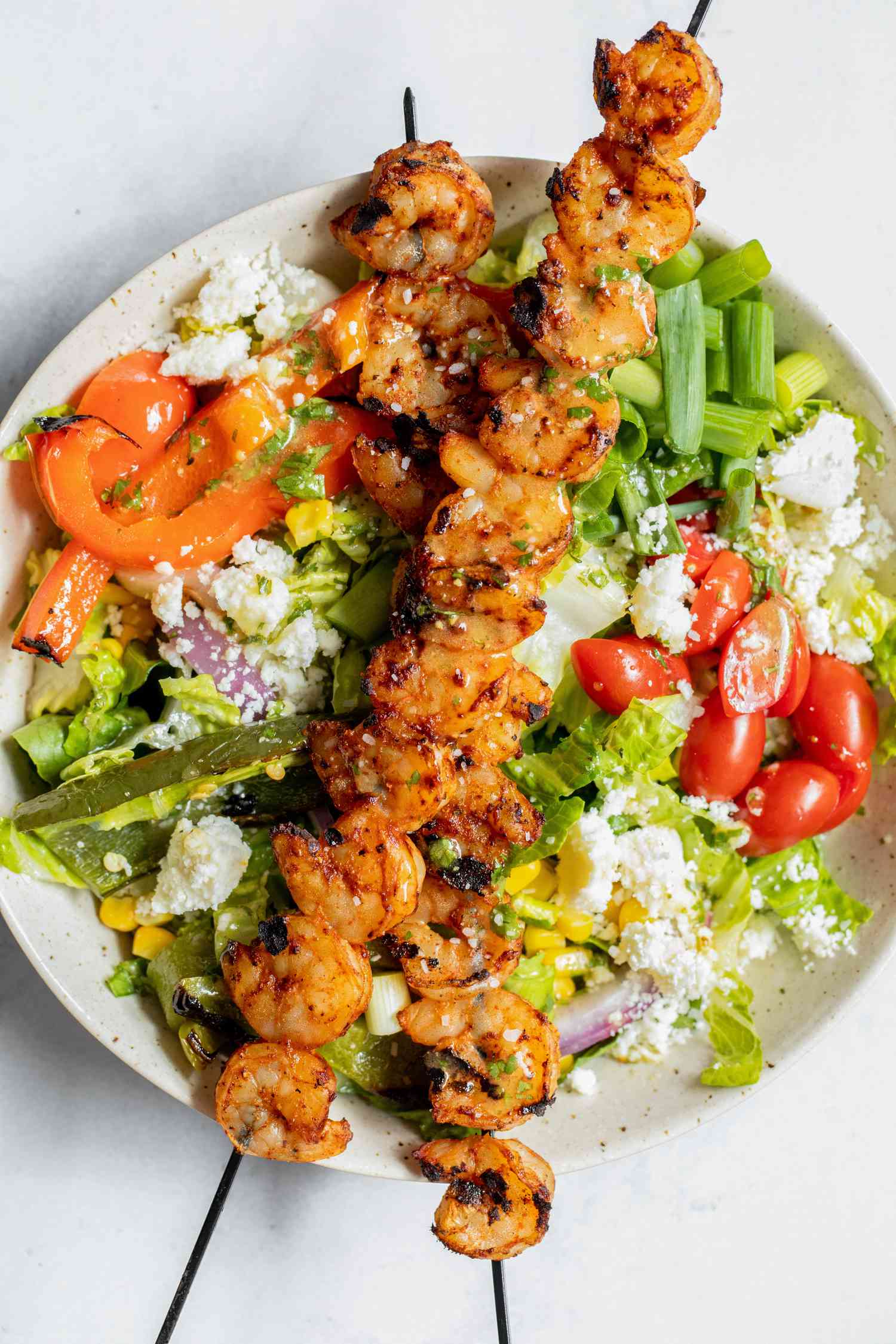 Bowl of Grilled Shrimp Salad with Shrimp on Skewers