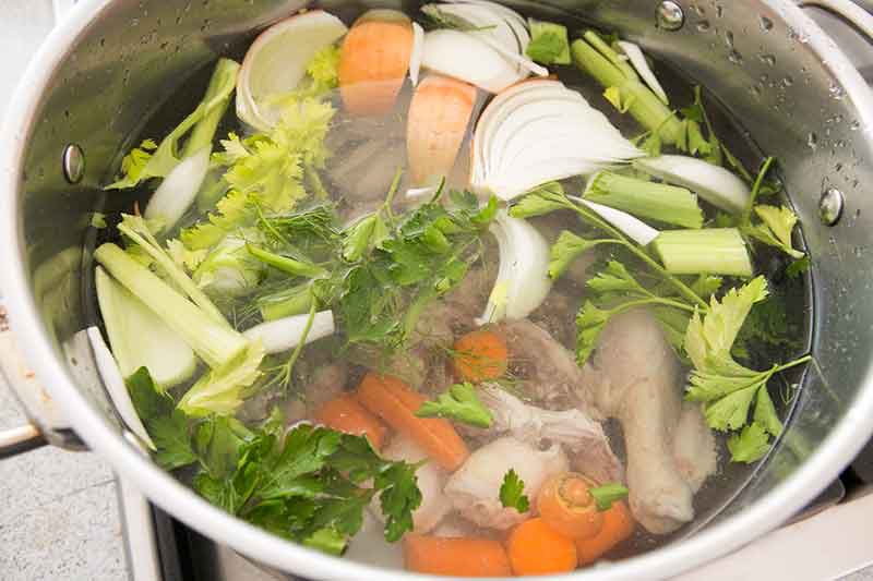 Raw Ingredients in Cooking Pot to Make Chicken Noodle Soup Stock From Scratch 