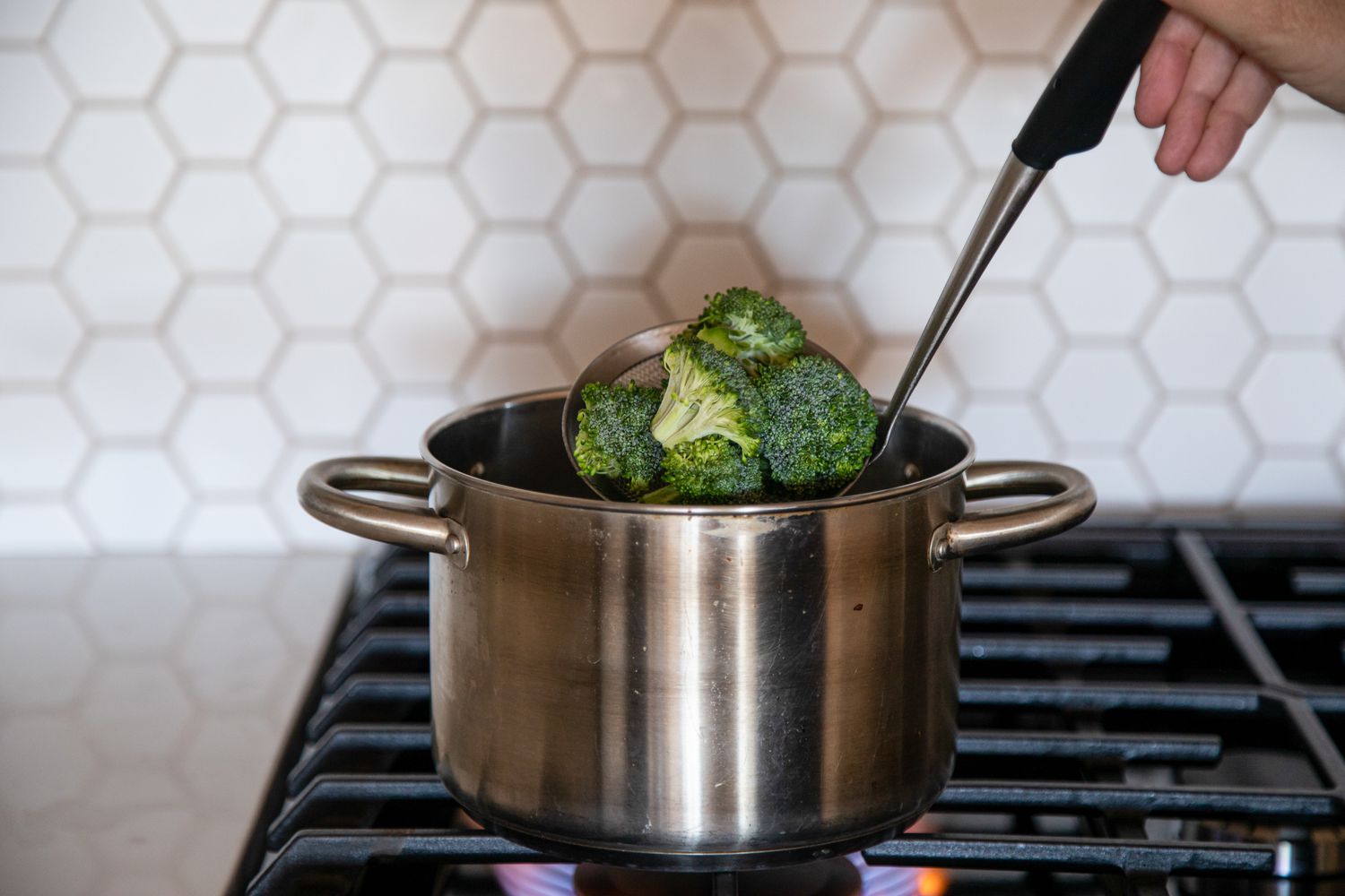 Broccoli Florets Ladled into Pot of Boiling Water for How to Blanch Broccoli