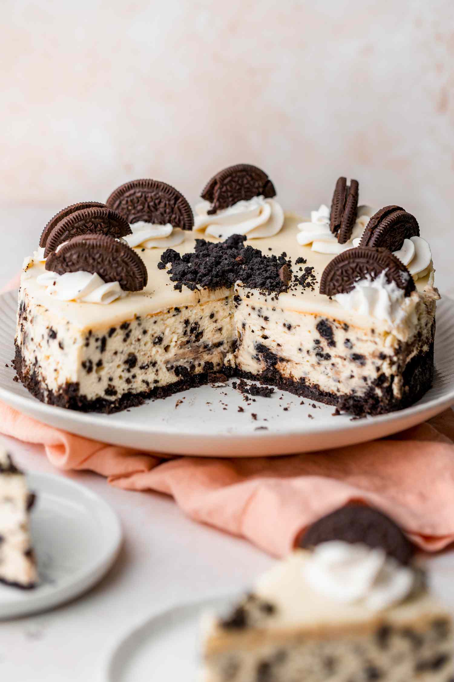 Cut Oreo cheesecake on a plate with slices in the foreground