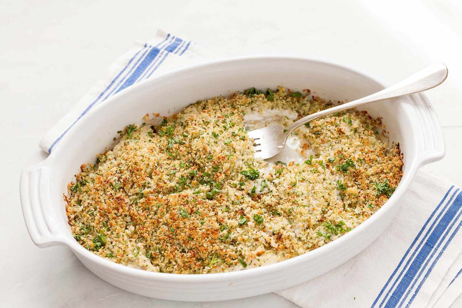 Baked flounder dish with breadcrumb topping served in a white baking dish