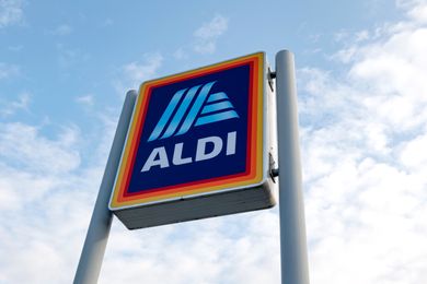 An Aldi storefront sign with a clear sky background