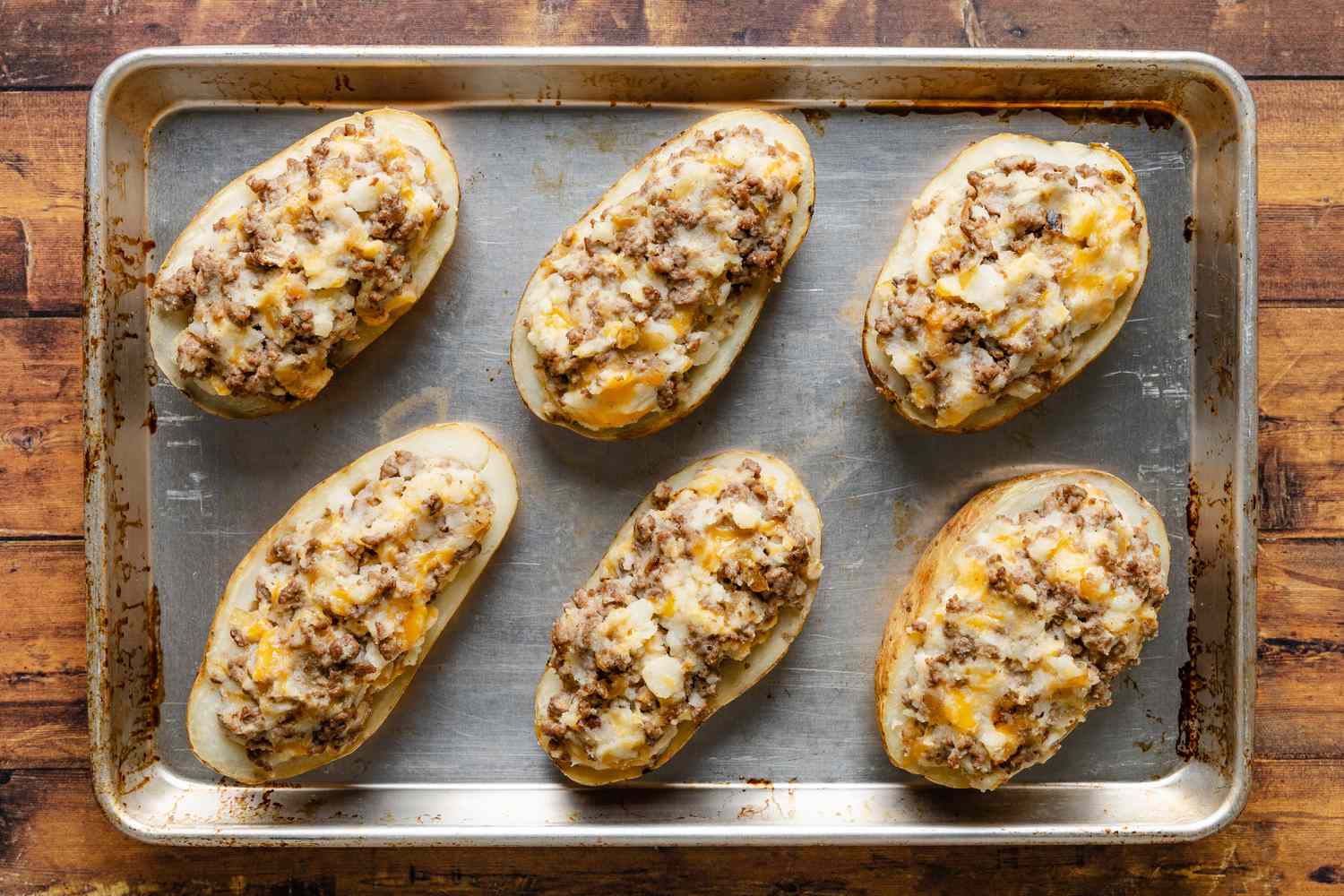 baked cheeseburger stuffed baked potatoes on a baking sheet 
