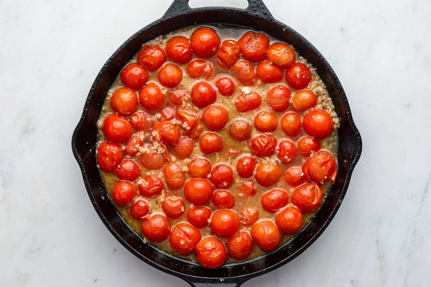 grape tomatoes and chicken stock added to the cast iron skillet for chicken pomodoro recipe