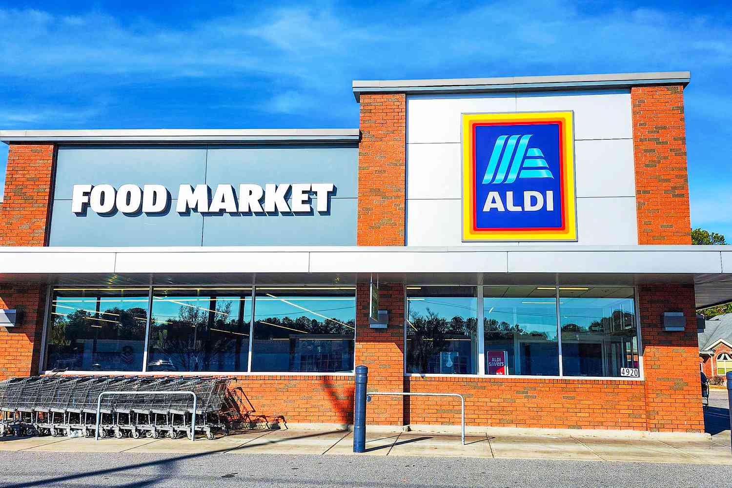 The storefront of an Aldi food market with shopping carts arranged outside