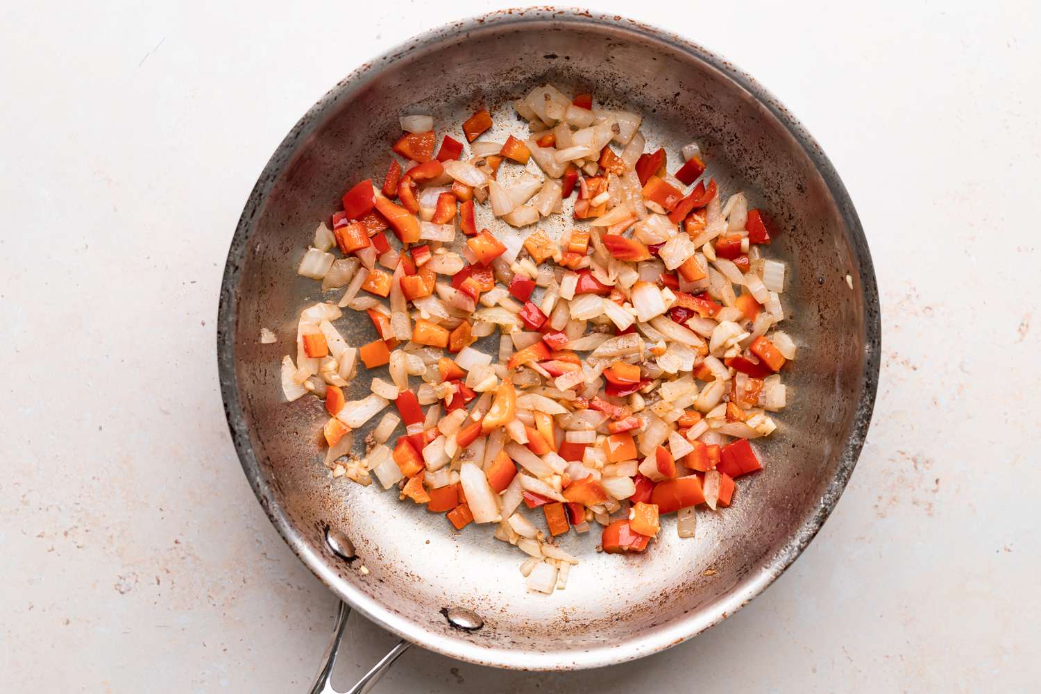 Sauteed onions and red peppers in a skillet for a lasagne recipe