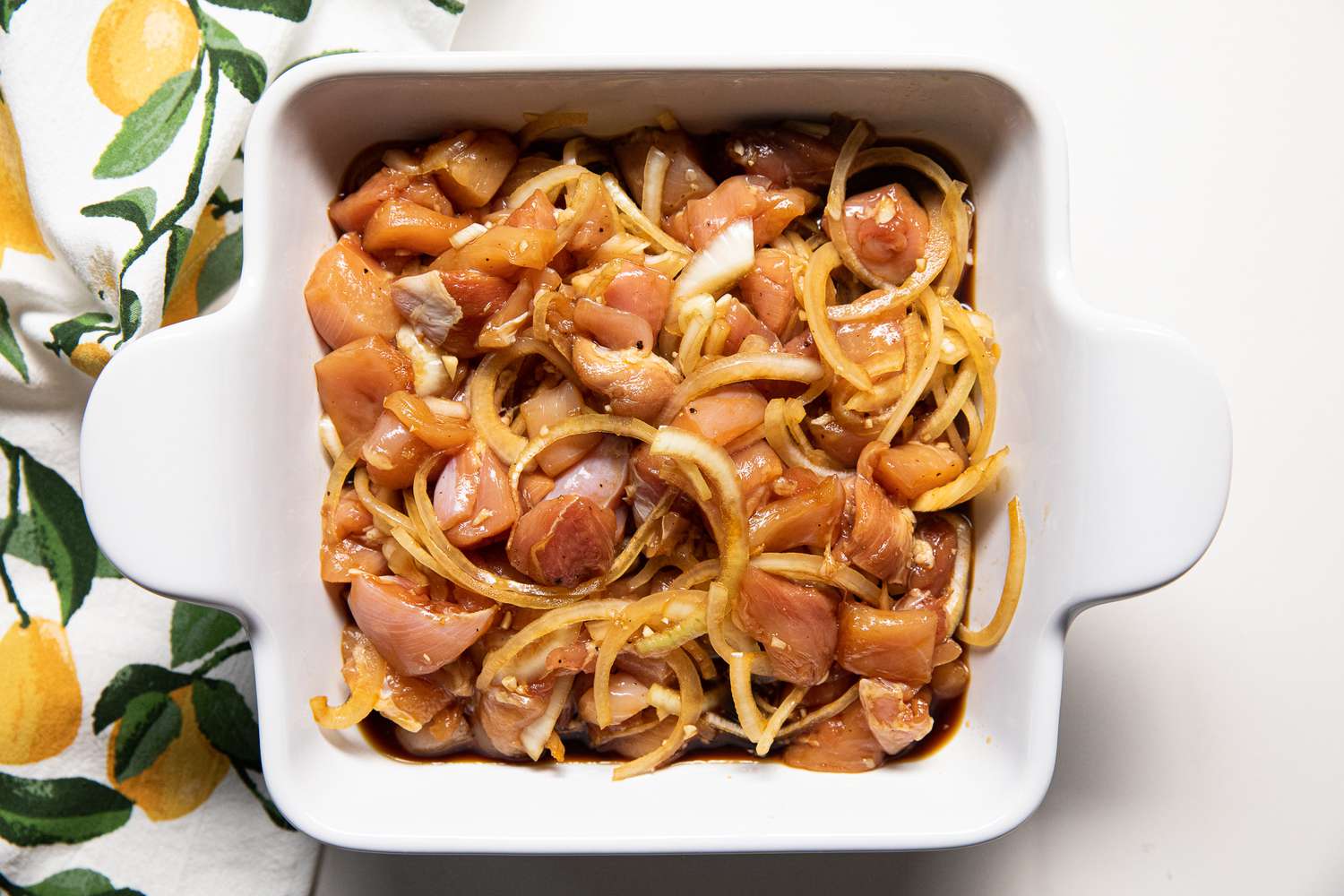 Chicken, Onions, and Seasoning in a Baking Dish for Microwave Oyakodon Recipe