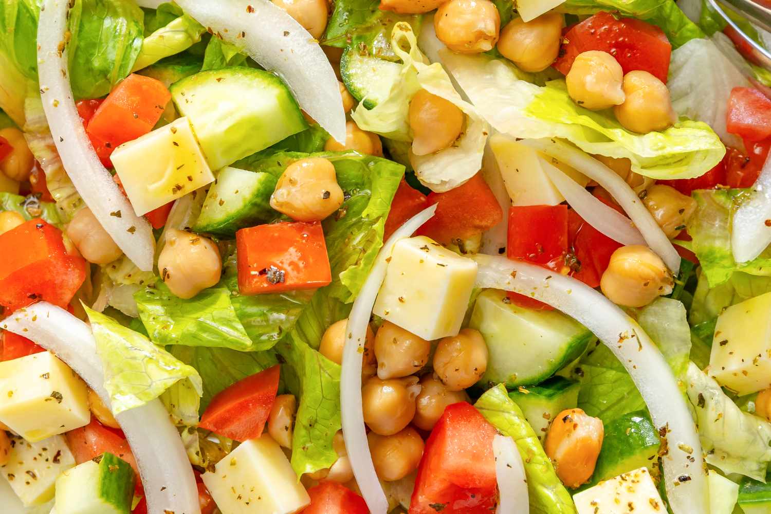 Sicilian chopped salad with lettuce tomatoes chickpeas cheese cubes cucumber and onion slices
