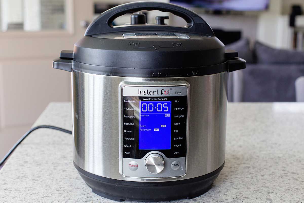 Instant Pot on a countertop with the timer set to 5 minutes.