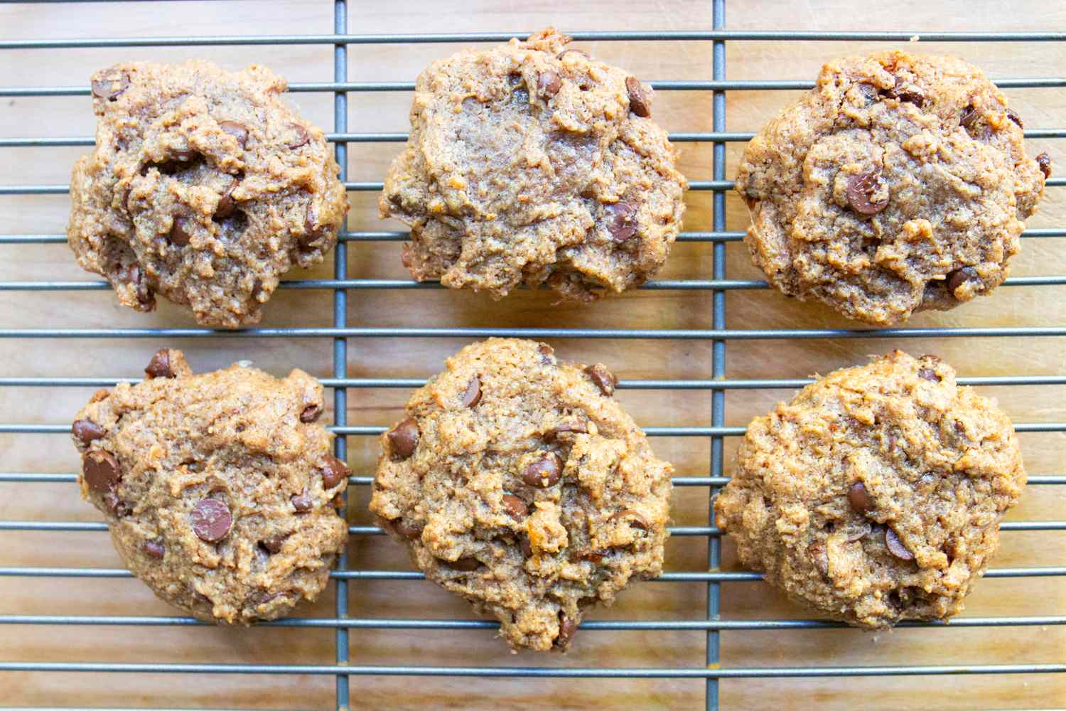 Six chocolate chip cookies on a cooling rack