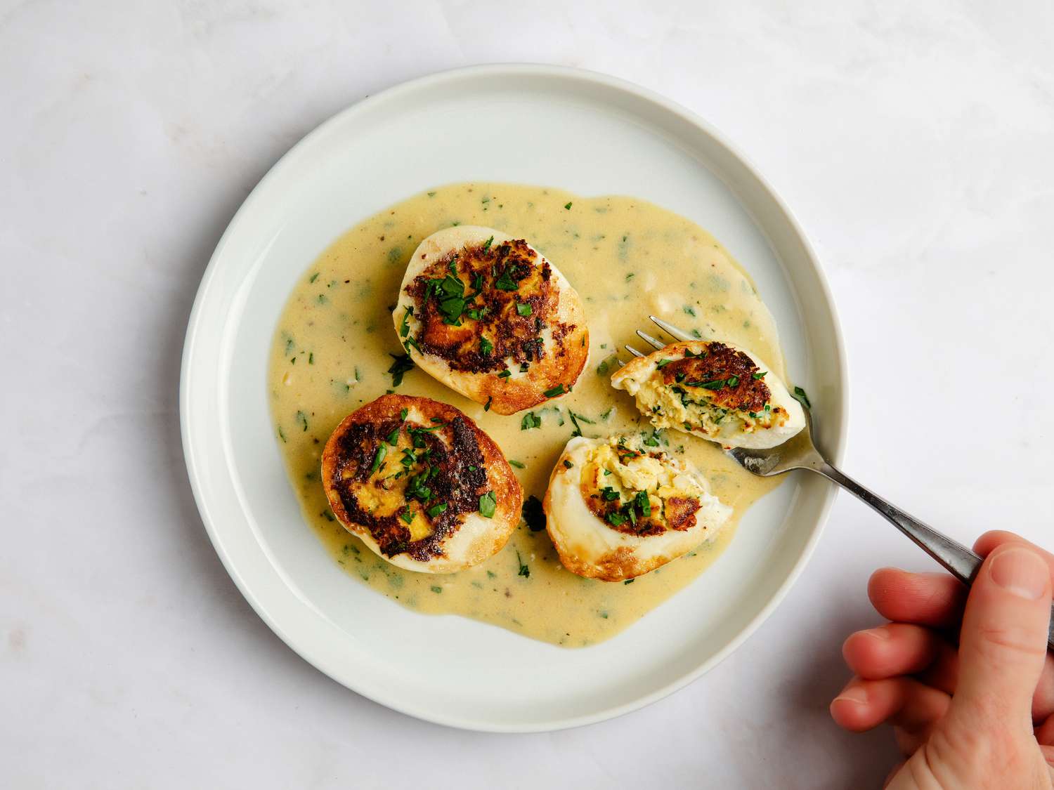 View from above of Pepin Eggs dish and hand with fork