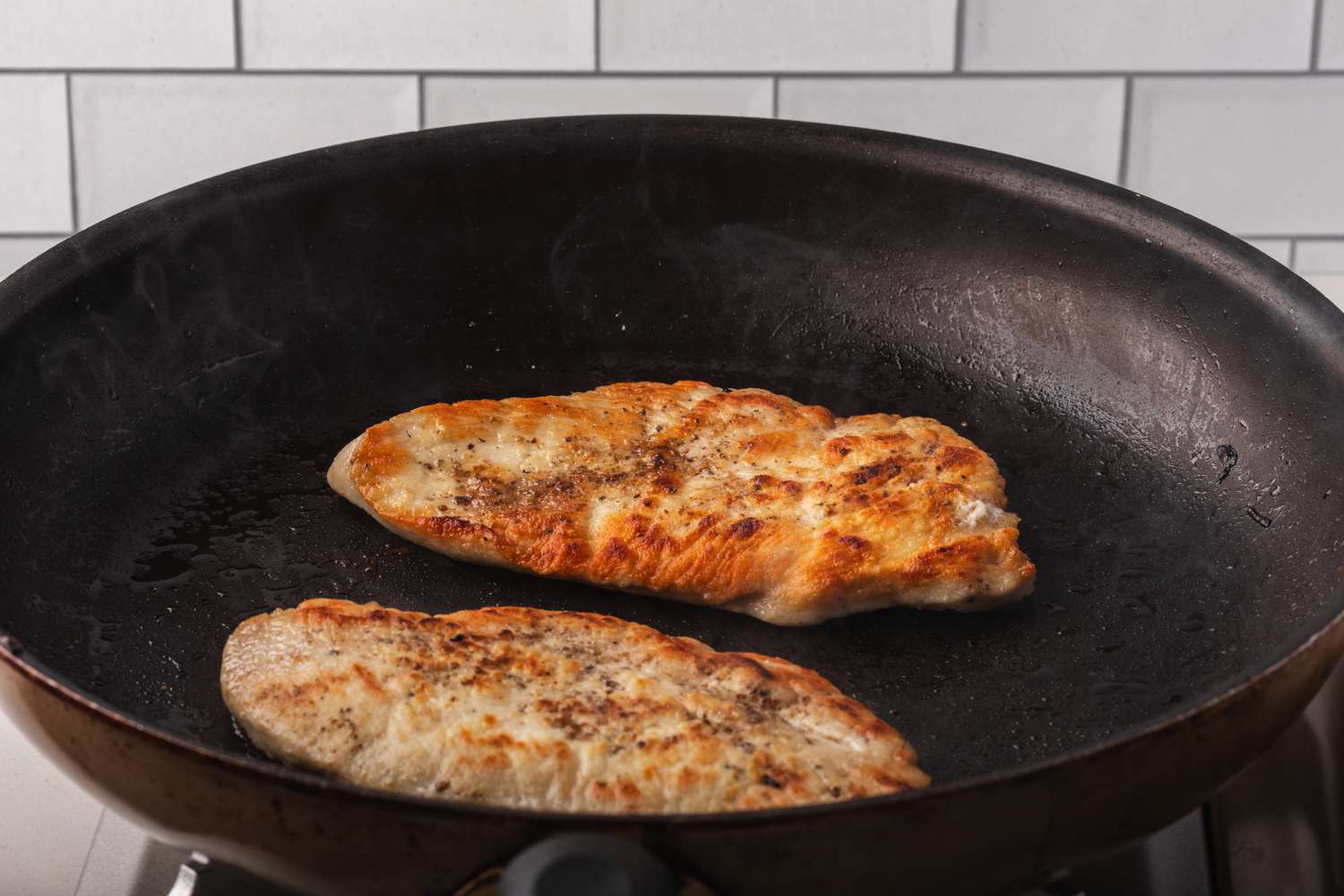 Pan frying chicken to make creamy chicken marsala.