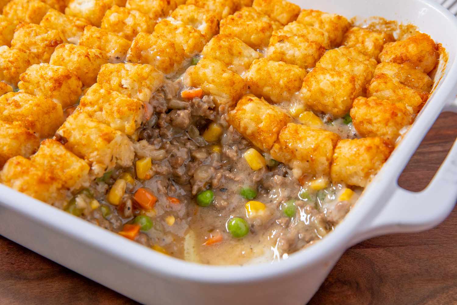 Classic Tater Tot Hotdish in a baking dish with one scoop removed