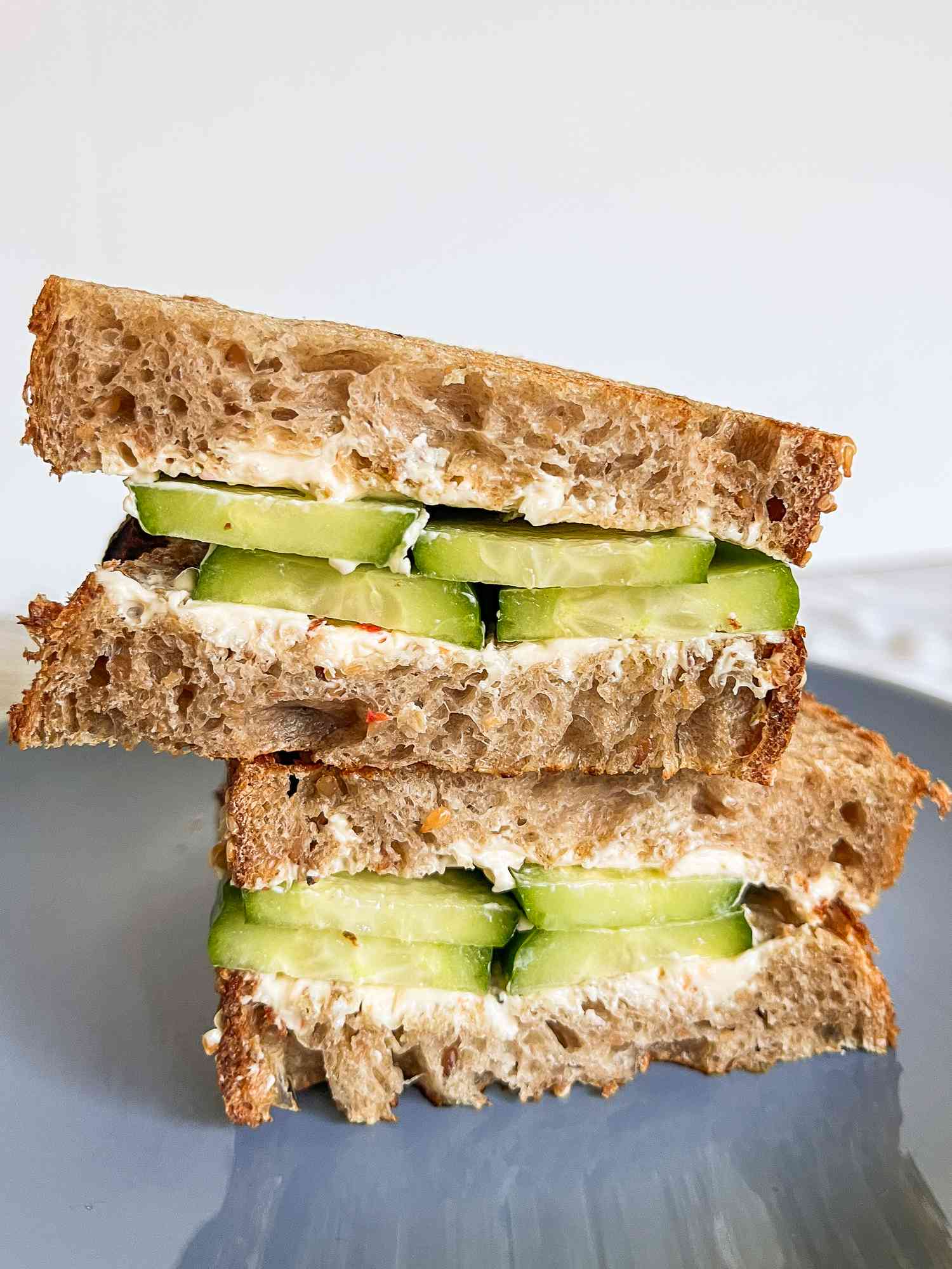 2-ingredient cucumber sandwich halves stacked on a plate 