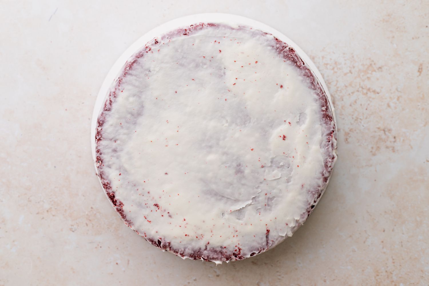 Apply the crumb coat to the red velvet cake