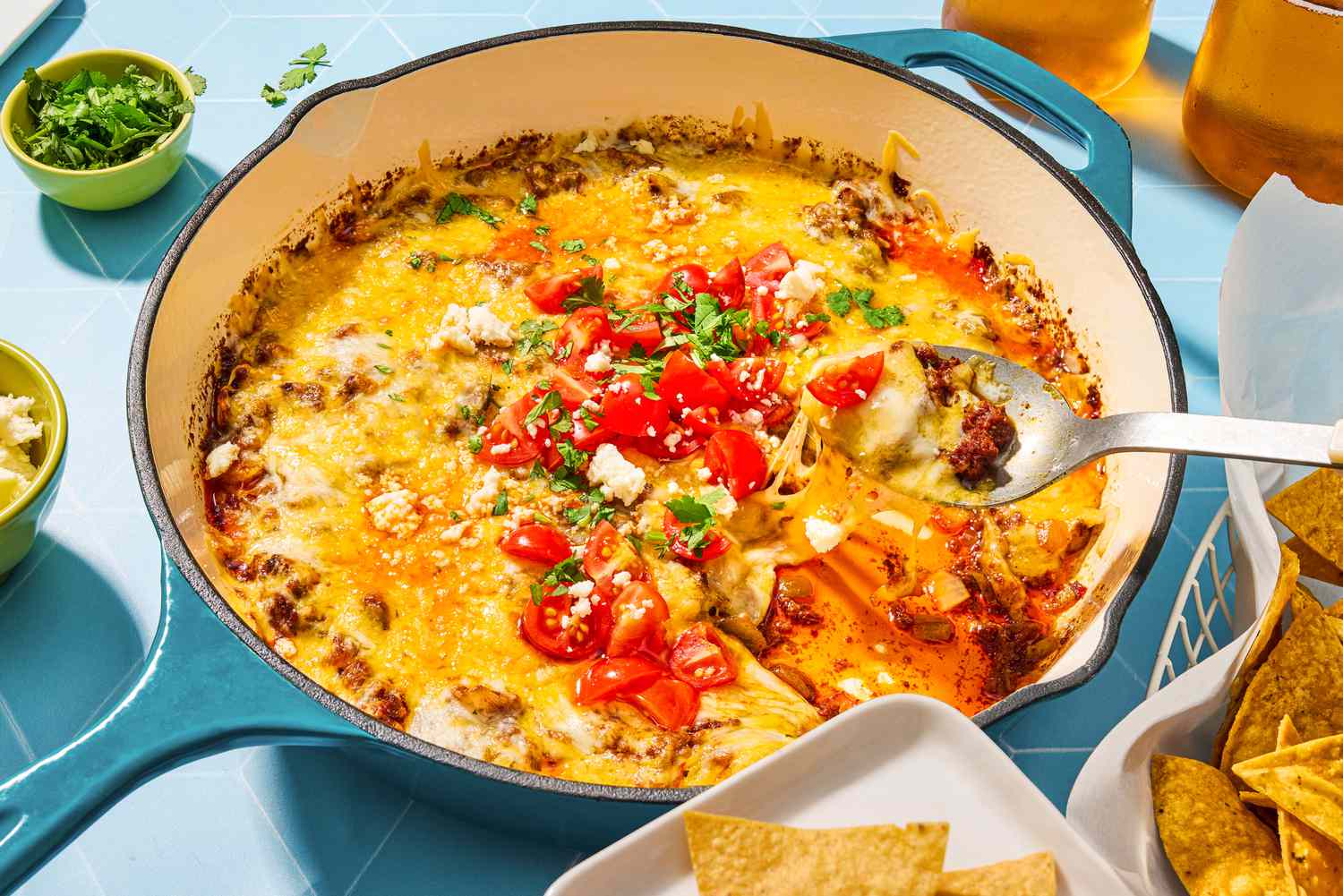 Queso Fundido in a skillet, spoon with dip above skillet