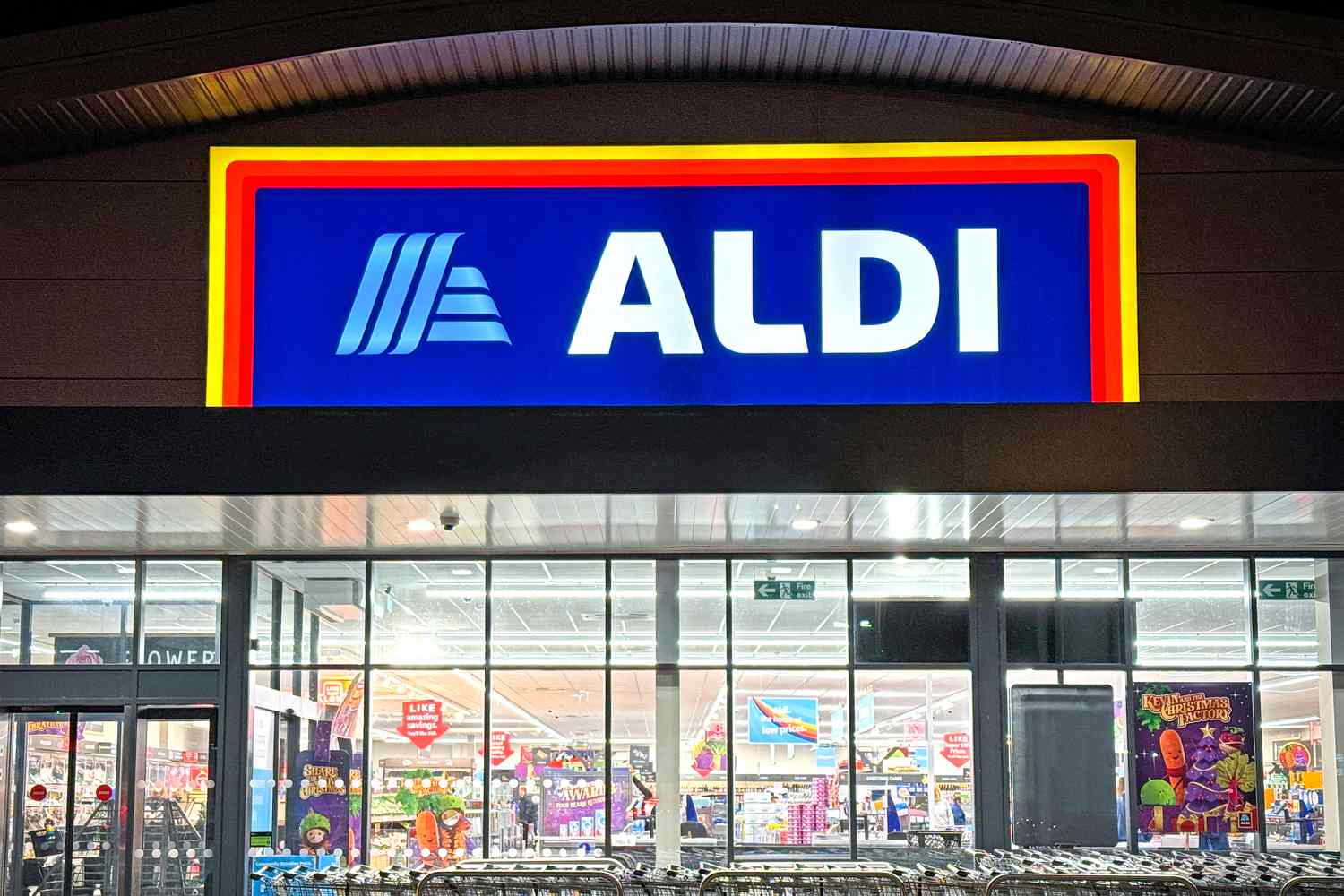 ALDI storefront at night with lit sign and visible interior