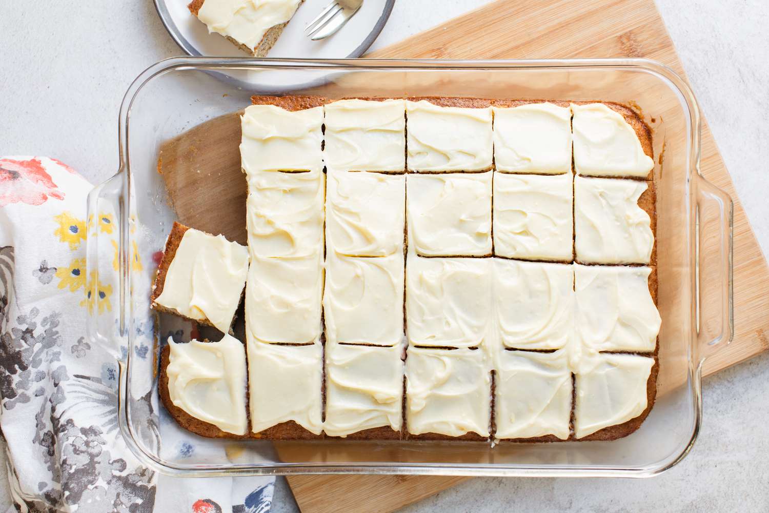Banana Sheet Cake Frosted and Cut into Portions in a Glass Baking Dish