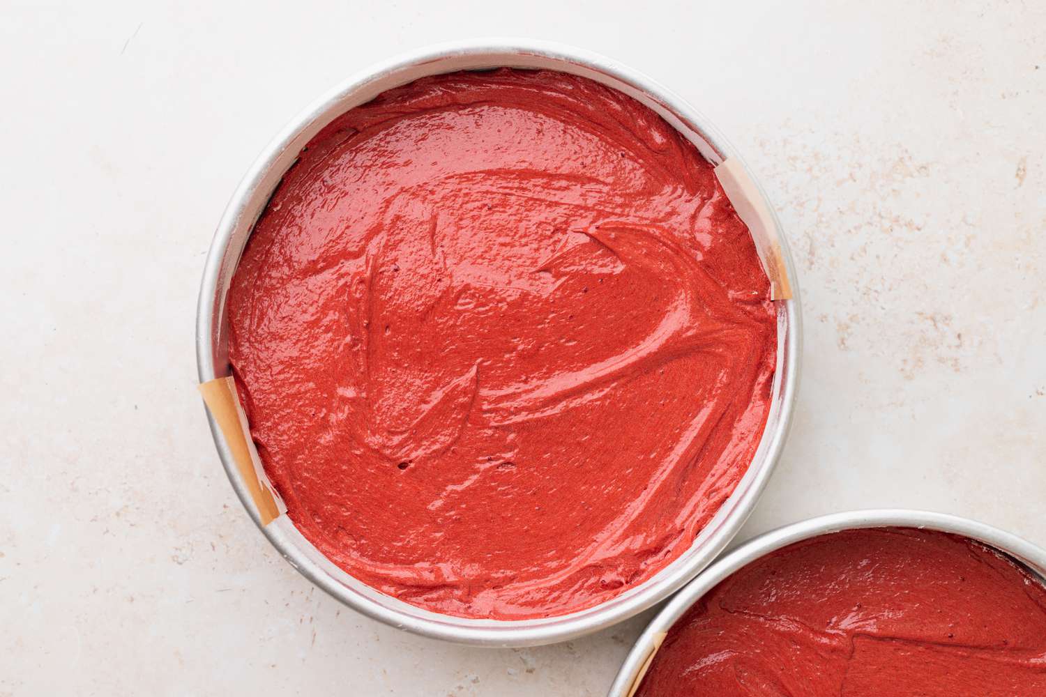 Divide the batter between pans to bake red velvet cakes 