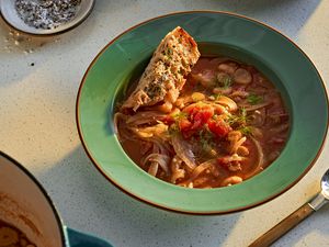 A bowl of tomato, white bean, and fennel stew on a kitchen counter