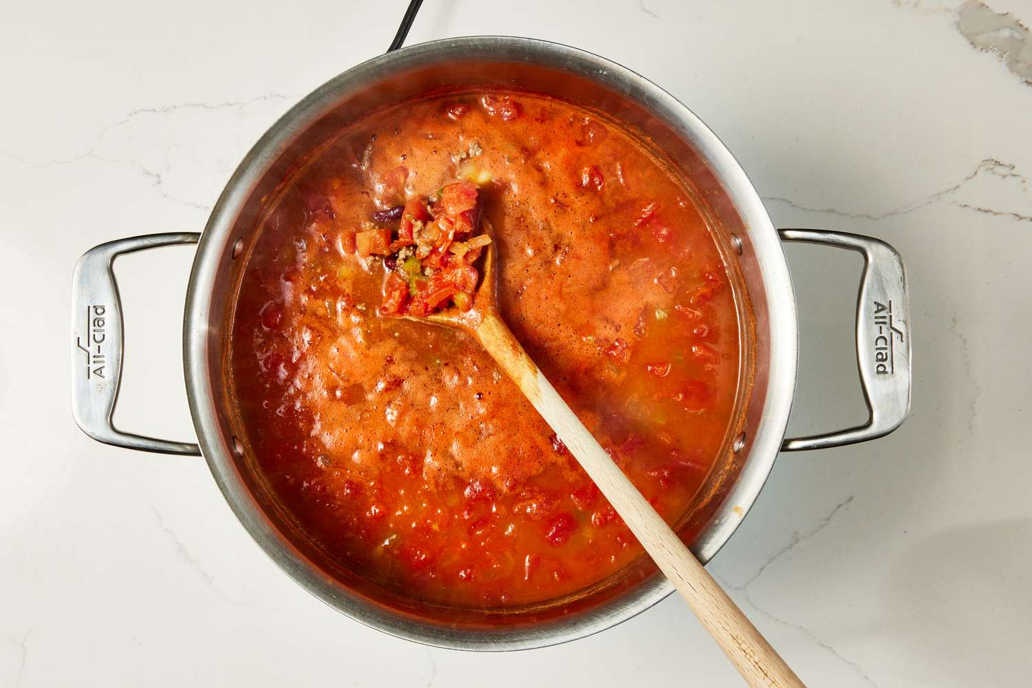 Wooden spoon stirring copycat Wendy's chili in a pot