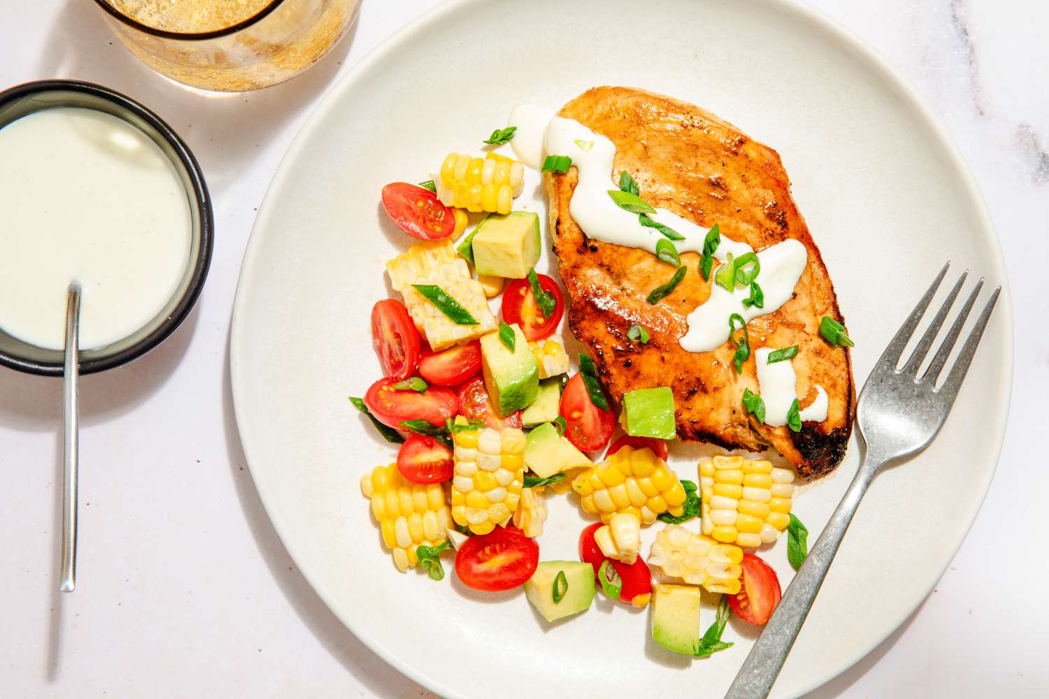 bowl of ranch chicken with halved grape tomatoes and corn pieces