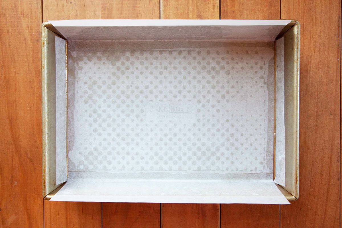 A baking pan lined with parchment paper to show How to Make Gingerbread Bars.