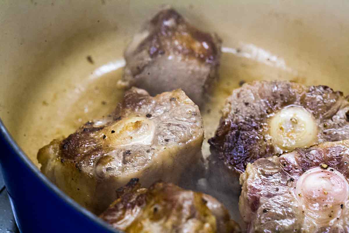 Oxtails cooking in a Dutch oven