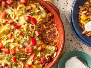 Bowl of chili dip with a serving in a bowl next to it 