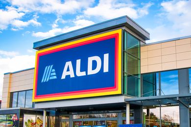 The frontage and brand logo of a branch of German discount retailer Aldi, taken in a local retail park on Wirral, UK on a sunny afternoon