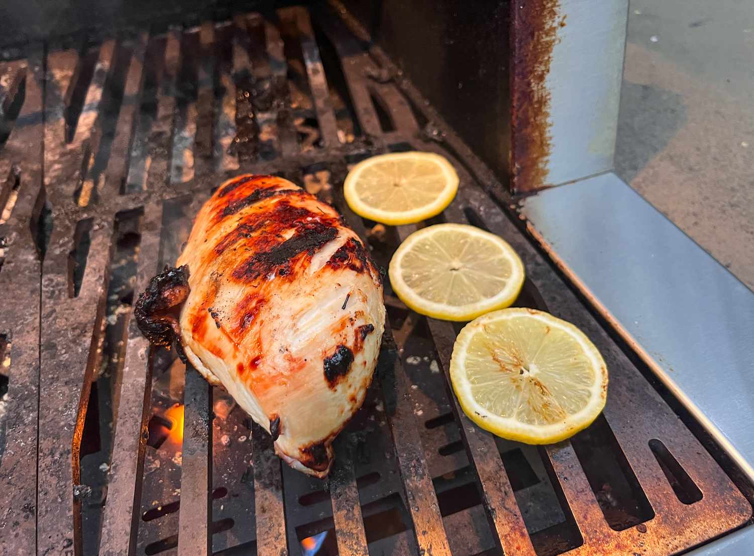grilled chicken on a grill with lemon slices