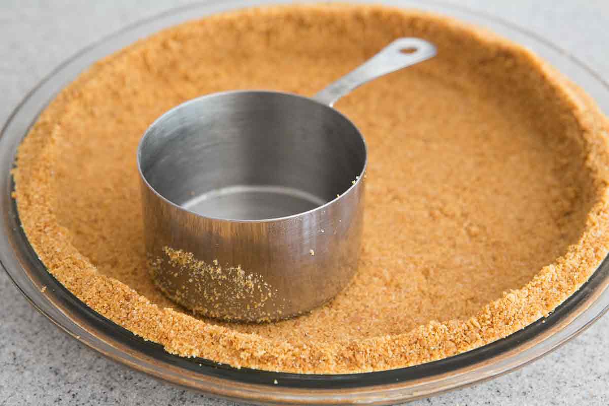 Pressing graham cracker crust into pie dish for key lime pie