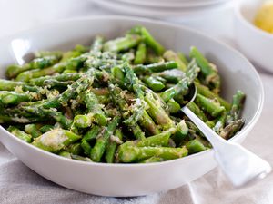 Asparagus with shredded Parmesan in a bowl with a spoon