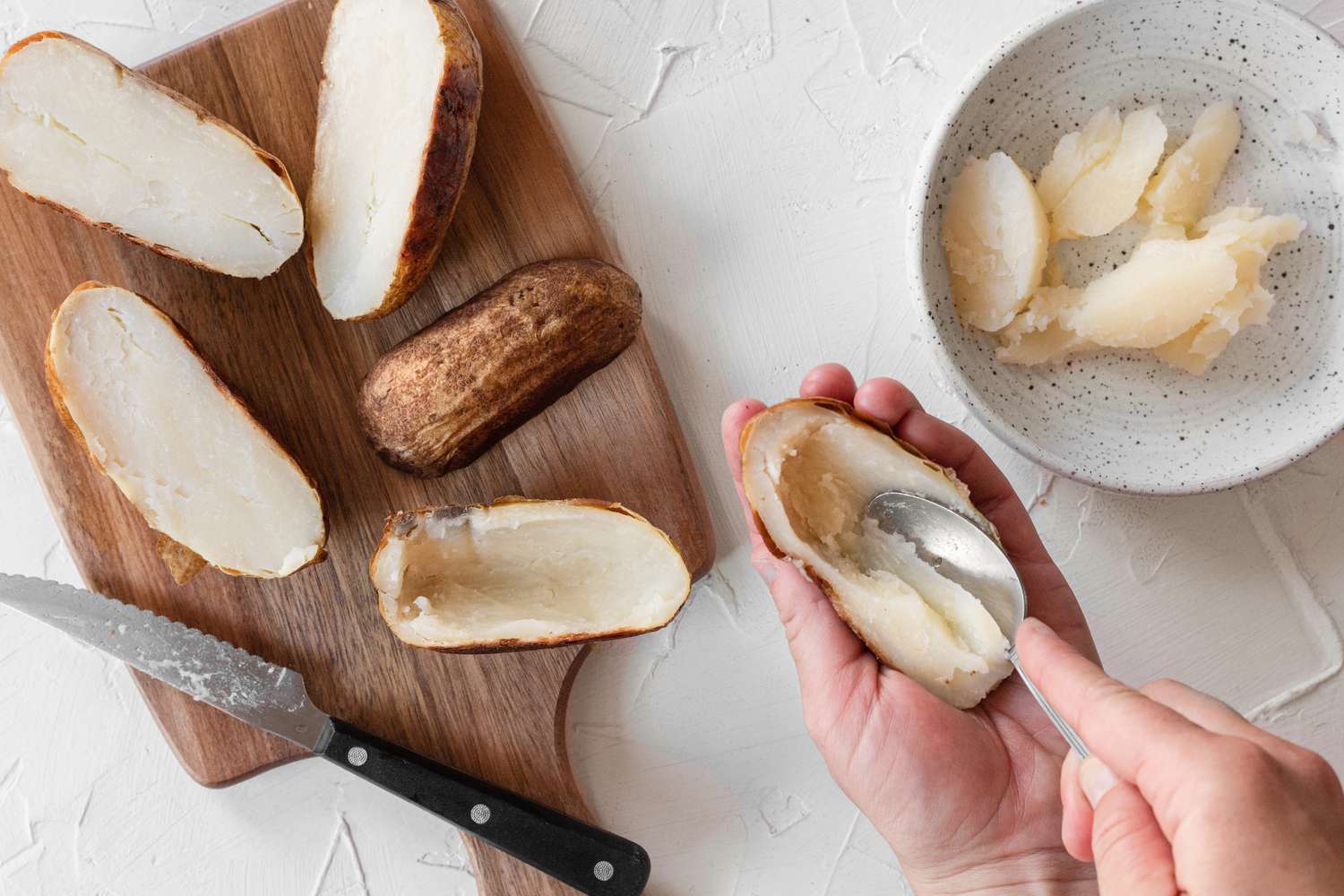 Scooping out the potato flesh to show how to make potato skins.