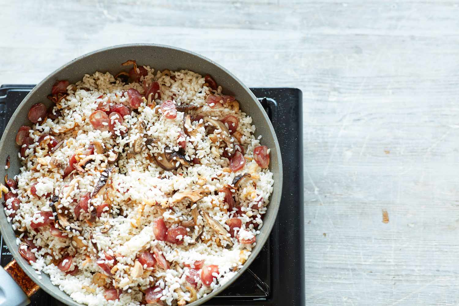 Ingredients in a skillet to make steamed rice with sausage, dried shrimp, and mushrooms
